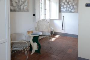 um quarto com duas cadeiras, uma mesa e uma janela em L'Albero Di Gamelì em Chiusi