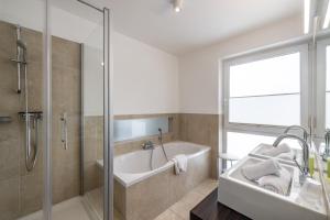 un bagno con vasca, lavandino e doccia di Apartments Schluga a Hermagor Altre 37 foto