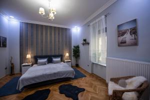 Schlafzimmer mit blauen Wänden, einem Bett und einem Stuhl in der Unterkunft Jacks's Home apartman - free parking in Pécs