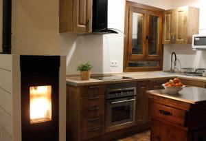 una cocina con chimenea en el medio. en Casa Albana Pirineos, en Gistaín