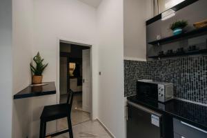eine Küche mit einer Mikrowelle und einem Stuhl darin in der Unterkunft Jacks's Home apartman - free parking in Pécs