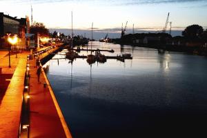 un puerto deportivo con barcos en el agua por la noche en Seaside Vitolu street Apartment, en Liepāja