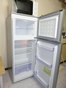 an empty refrigerator with its door open in a kitchen at ザミッキーカールトン井尻102 in Shiobaru