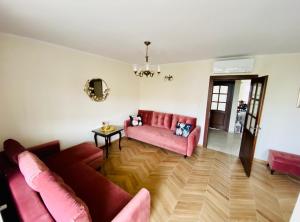 sala de estar con sofá rosa y mesa en Apartament Prestige Pruszków, en Pruszków