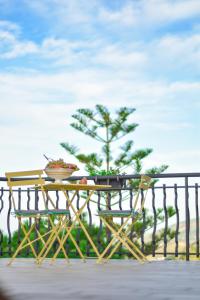 een tafel en stoelen met een boom op een hek bij Nnakkara Guest House in Santo Stefano di Camastra