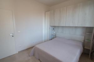 Dormitorio pequeño con cama blanca y armarios en Bilocale nuovo con vista mare e posto auto en Varazze