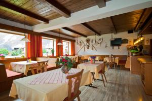 een restaurant met 2 tafels en stoelen en een keuken bij Pension Arnspitze in Scharnitz