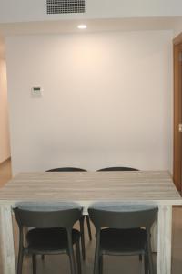tavolo e sedie in una stanza con parete bianca di APARTAMENTOS AGUAMARINA a Peñíscola