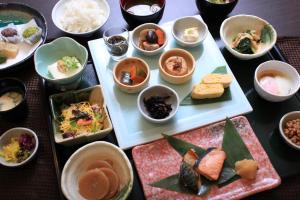 a table with plates of food and bowls of food at Urban Hotel Kyoto Nijo Premium in Kyoto