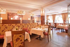 um restaurante com mesas e cadeiras num quarto em Seehotel Sparer em Appiano sulla Strada del Vino