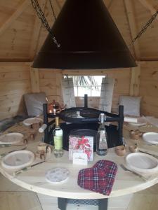 einen Tisch mit Tellern und Flaschen in einer Kabine in der Unterkunft La Grande Ferme in La Chapelle