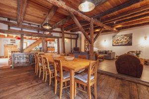 a dining room with a wooden table and chairs at Maison Amalka in Montgenèvre