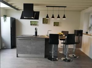 a kitchen with a island with bar stools in it at Ô'bel Écrin in Aubel