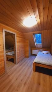 a bedroom with a bed in a wooden room at Purgaiļi in Smiltene