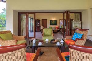 a living room with chairs and a table and a room at Villa Amaaya - The Hidden Gem by StayVista in Alibaug