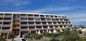 un edificio de apartamentos con una furgoneta estacionada frente a él en Studio Naturiste "Relax" Héliopolis E 88, en Cap d'Agde