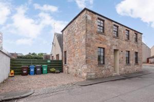 an old brick building with trash cans in front of it at The Howff - Lovely 2-Bed Apartment in Anstruther in Anstruther