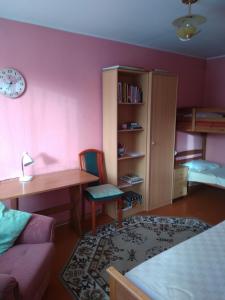 
a bedroom with a bed, desk, and chair at Rogosi Külaliskorter in Ruusmäe
