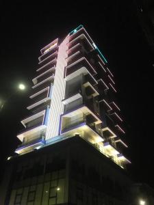 馬德望的住宿－V V Hotel Battambang，一座高大的建筑,上面有灯,晚上