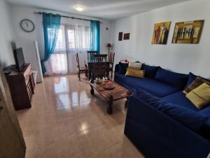 コラレホにあるAppartamento Spagnolo Oasis Tamarindoのリビングルーム(青いソファ、テーブル付)