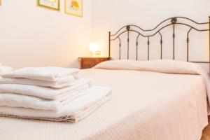 a pile of towels sitting on top of a bed at Albergo Residenziale Menhirs in Putzu Idu