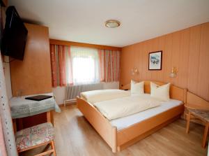 una camera da letto con un letto e una televisione di Pension Arnspitze a Scharnitz