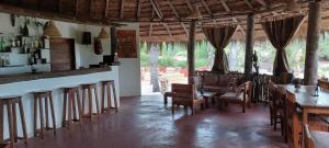 a restaurant with a bar and tables and chairs at Esperanto Lodge in Kafountine