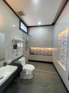 y baño con aseo y lavamanos. en Phutara Resort and Spa, en Buriram