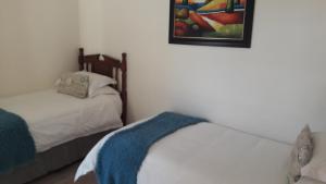 1 dormitorio con 2 camas y un cuadro en la pared en Victoria & Alfred Boutique Hotel en Puerto Elizabeth