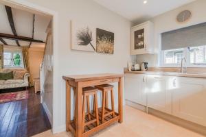 a kitchen with a counter and stools in it at Corner Cottage in Bretforton