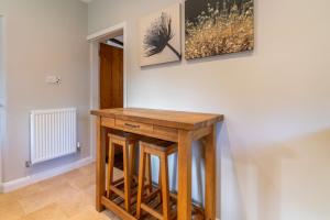 a table in a room with two paintings on the wall at Corner Cottage in Bretforton +15 photos