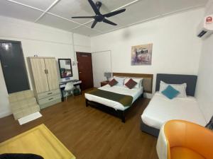 a bedroom with two beds and a ceiling fan at BoraBora Beach Guesthouse Penang in George Town