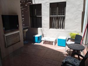 a patio with a tv and a table and chairs at Dream Catcher Mykonos Beach House in Langebaan