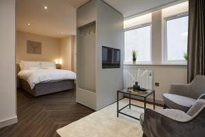 a bedroom with a bed and a tv and a couch at Humber Lofts Apartments in Hull