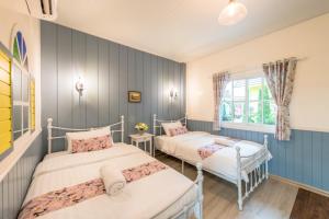 two beds in a room with blue walls at Baan Kang Hun Pua Cottage in Pua