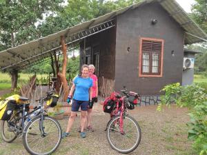 two people standing in front of a house with bikes at Ceylon Resort Wilpattu in Wilpattu