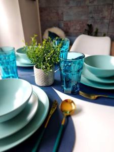 un tavolo blu con piatti, ciotole e un cucchiaio di Stylish 2 bedroom Apartment / FREE Gated Parking a Glasgow