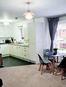 a kitchen with a table and chairs and a dining room at Stylish 2 bedroom Apartment / FREE Gated Parking in Glasgow