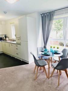 a dining room with a table and chairs in a kitchen at Stylish 2 bedroom Apartment / FREE Gated Parking in Glasgow