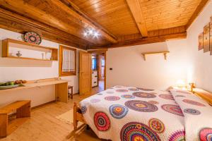 Un dormitorio con una cama grande en una habitación con techos de madera. en Charming Tabià en Rocca Pietore