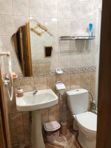 a bathroom with a sink and a toilet and a mirror at Venta City Apartment in Venta +16 photos