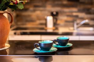 two coffee cups sitting on a counter with a vase at Eakley Stables 1 - Woody 