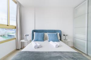 una camera da letto con un letto grande con cuscini blu di Home2Book Design Las Canteras2 Beach a Las Palmas de Gran Canaria Altre 33 foto