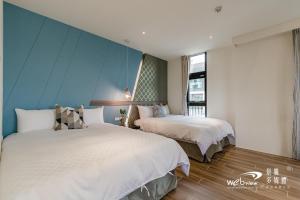 two beds in a room with blue walls at Xiao Tian Di Homestay in Taitung City
