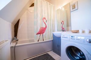two pink flamingos standing in a bathroom next to a washing machine at Calvaloft in Bons-Tassily