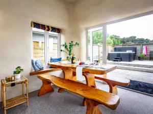 uma sala de estar com uma mesa e bancos e uma grande janela em The Yellow Straw House - Rangataua Holiday Home em Ohakune