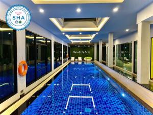 ein Schwimmbad in der Mitte eines Gebäudes in der Unterkunft The Vet Boutique Hotel - SHA Extra Plus in San Kamphaeng