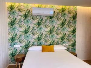 a bedroom with a bed with a tropical wallpaper at Cabañas Fisterra in Fisterra