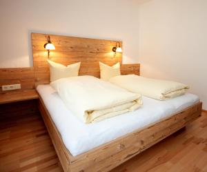 a bedroom with a bed with a wooden headboard at Pension Arnspitze in Scharnitz
