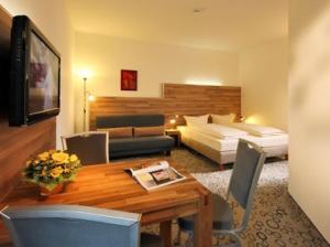 a hotel room with a bed and a dining table at Petul Apart Hotel Am Ruhrbogen in Bochum